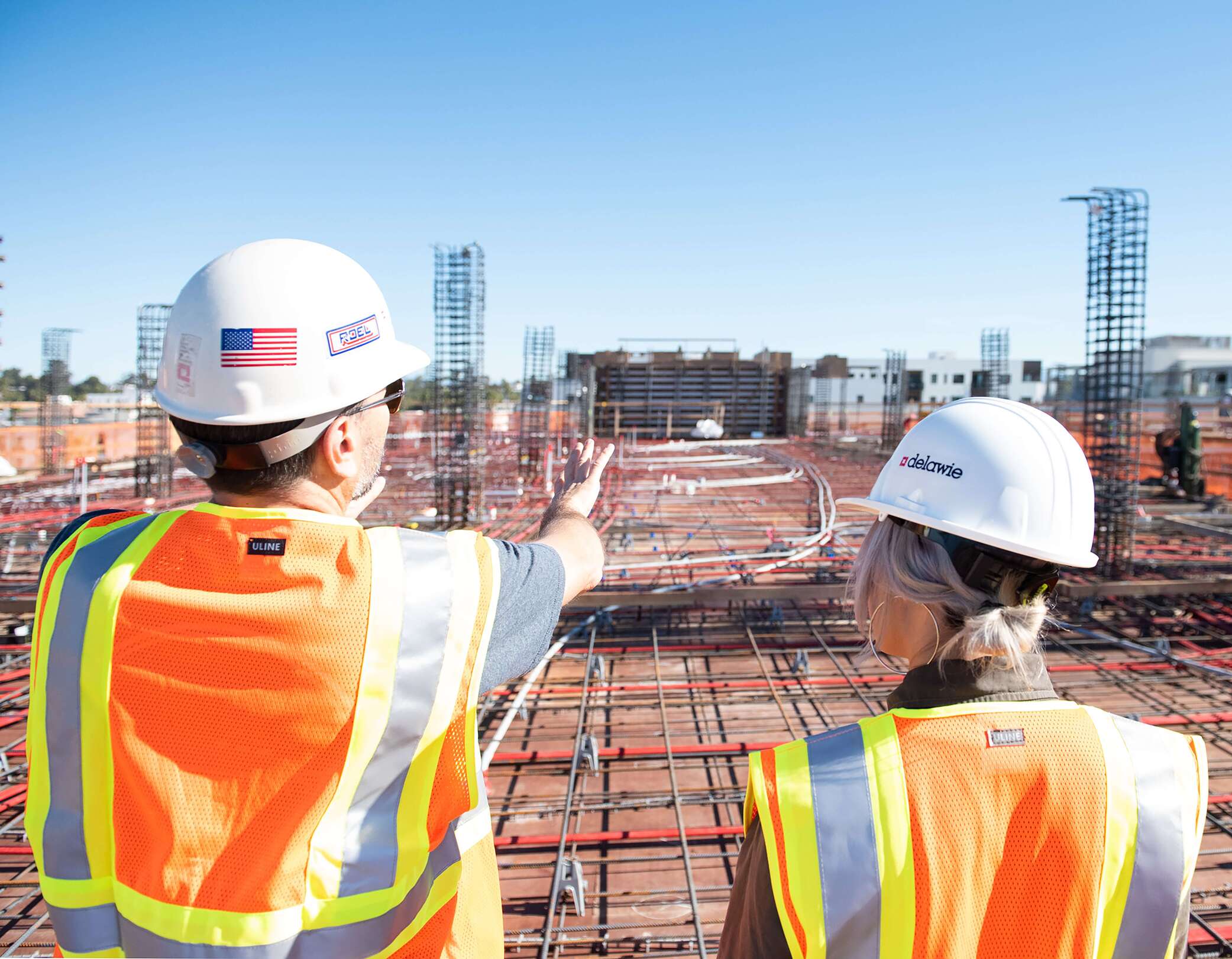 man in white hard hat standing overlooking construction site