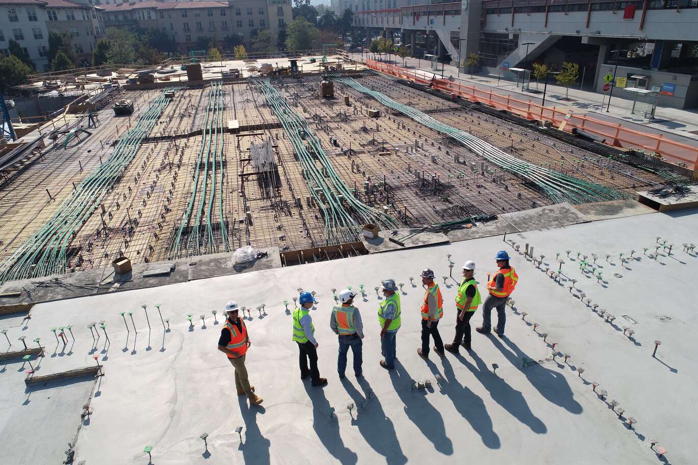 seven construction workers standing on top of concrete slab