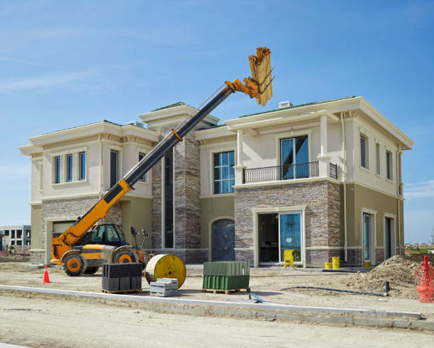 excavator in front of house under construction